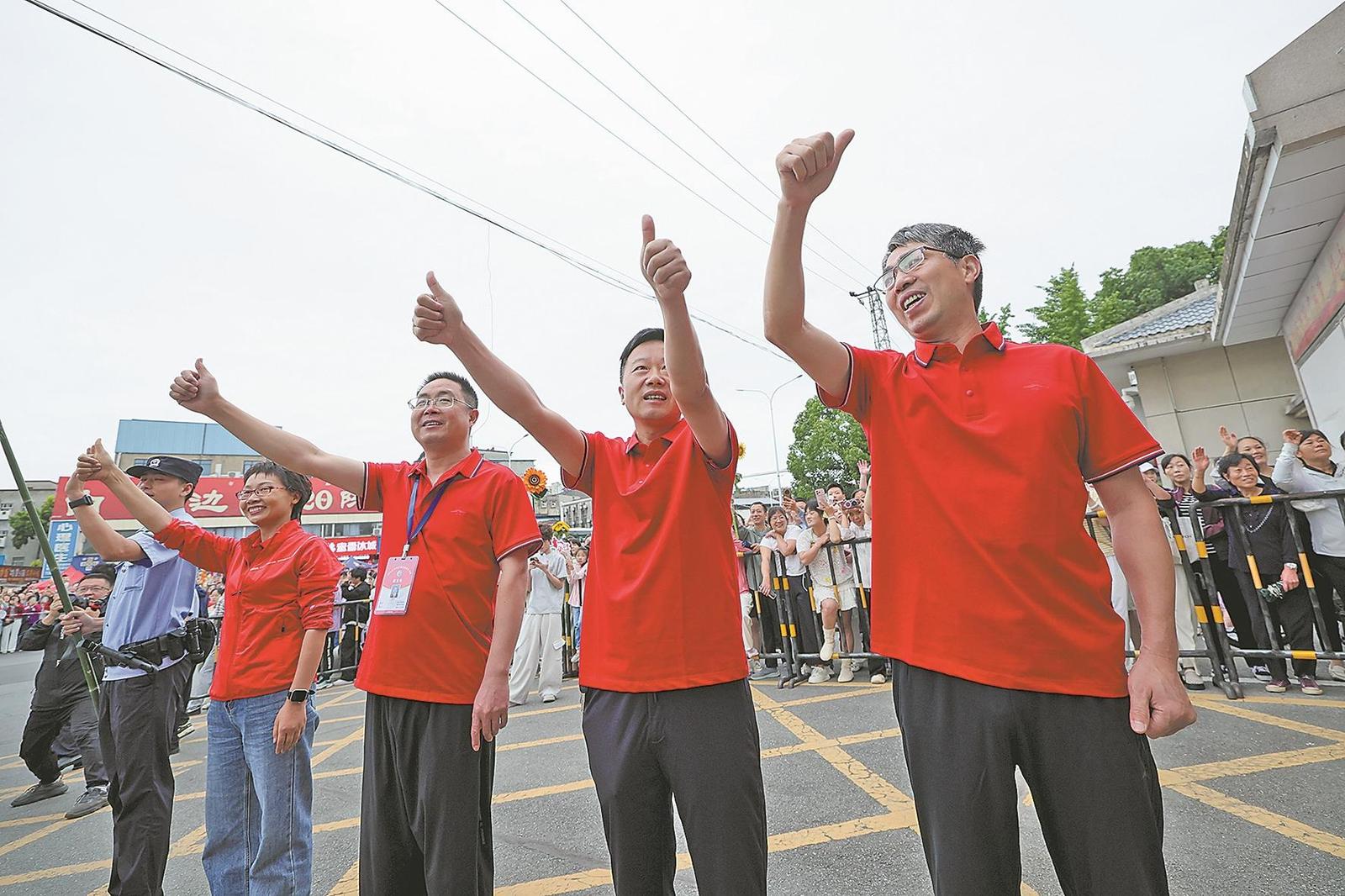 6月7日,在襄阳五中考点,老师身穿红衣为考生加油 记者杨东 摄