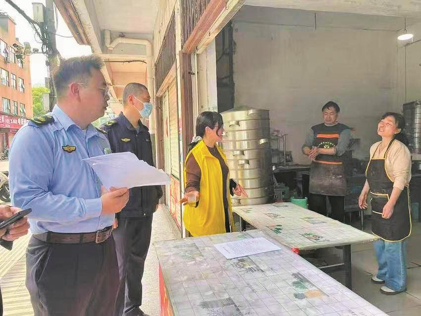 城管队员讲解市容管理法律法规。记者 刘自航 通讯员 周爽 摄